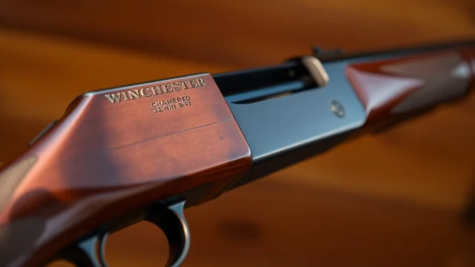 ps6s A detailed shot of a 32WIN Winchester rifle in a natural outdoor setting, highlighting the cartridge and lever-action mechanism for firearm enthusiasts and hunters.